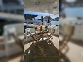 A beautifully arranged dining area on a boat featuring an array of delicious food and vibrant floral decorations, perfect for onboard gatherings and celebrations.