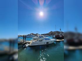 A stunning view of a luxurious yacht docked in a vibrant marina under a clear blue sky, perfect for showcasing upscale boating experiences.