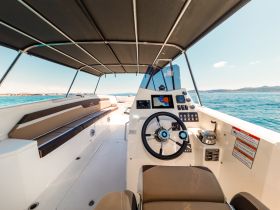 A spacious helm area of a boat featuring comfortable seating and modern navigation equipment, perfect for enjoying a day on the water.