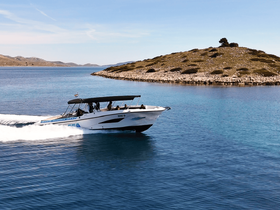 A sleek speedboat navigates through crystal-clear waters near a picturesque island, showcasing the thrill of boating adventures in stunning coastal scenery.