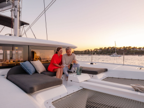 A couple enjoys a romantic moment on the deck of a yacht at sunset, sharing cocktails and creating unforgettable memories on the water.