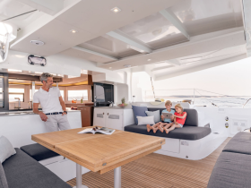 A cozy interior view of a modern boat featuring a man and two children enjoying their time together in the lounge area, perfect for family outings on the water.