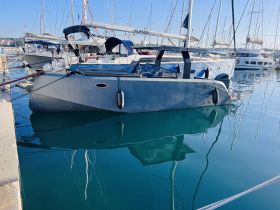 A sleek Phantom yacht docked in a marina, showcasing its modern design and reflective waters — perfect for luxury boating experiences.