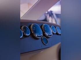 Close-up view of a boat's helm console featuring various gauges, showcasing the intricate details of marine instrumentation.