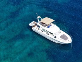 A stunning aerial view of a yacht cruising through crystal-clear waters, showcasing its elegant design and perfect for luxury charters.