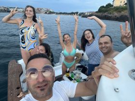 A fun group of friends celebrates on a boat, showcasing joyful moments and camaraderie against a scenic backdrop — perfect for summer outings and boat parties.