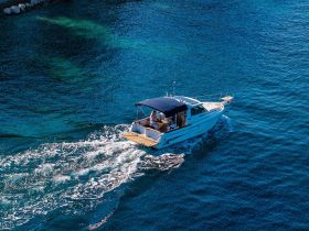 Aerial view of a sleek speedboat cruising through clear blue waters, showcasing the perfect vessel for exciting day trips on the water.