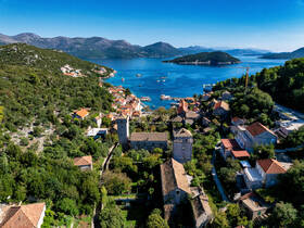 A stunning aerial view of a picturesque coastal village surrounded by lush greenery and tranquil waters, perfect for exploring the natural beauty of the region.
