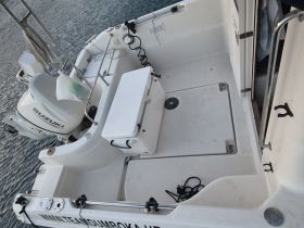 An interior view of a boat showcasing the seating and console area, perfect for fishing or leisure outings on the water.