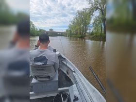 A fisherman enjoys a peaceful day on the river, casting lines and soaking in the natural surroundings — perfect for outdoor enthusiasts and fishing trips.