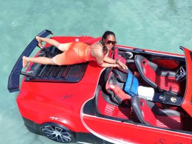 A woman enjoys a sunny day on a vibrant red jet ski, showcasing the thrill of water sports and summer fun.