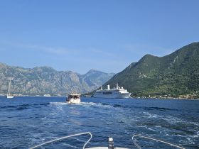 A scenic view of boats navigating through a stunning mountainous landscape, showcasing the beauty of a coastal cruise experience.