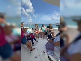 A lively group enjoys their time aboard a boat, sharing smiles and laughter under the sunny sky — perfect for memorable outings on the water.