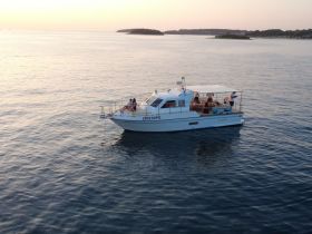 A couple enjoys a serene moment on a boat during sunset, surrounded by calm waters — perfect for romantic getaways or peaceful evenings on the water.
