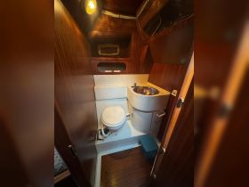 Interior view of a boat bathroom featuring a toilet and sink, showcasing the compact and functional design typical of marine cabins.