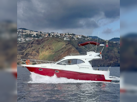 A sleek Starfisher yacht glides through the water, showcasing its elegant design against a stunning coastal backdrop.
