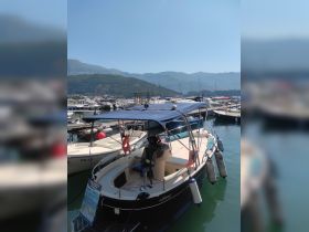 A well-maintained boat docked at a marina, showcasing its sleek design and inviting seating area, perfect for leisurely outings on the water.
