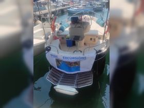 Interior view of a boat's helm area featuring seating and a banner advertising excursion options — perfect for those looking to explore the waters.