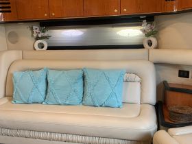 Cozy interior seating area of a boat featuring plush cushions and elegant decor, perfect for relaxing during a day on the water.