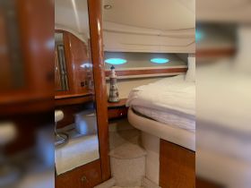 A cozy interior view of a boat cabin featuring a comfortable bed and decorative elements, perfect for relaxing on the water.