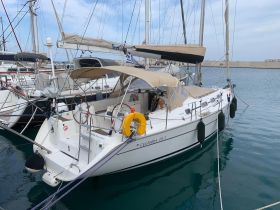 A beautiful Cyclades 39.3 yacht docked in a marina, showcasing its sleek design and spacious deck, perfect for sailing adventures.