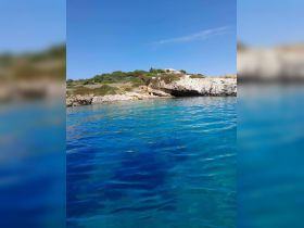 A stunning view of a rocky coastline and crystal-clear waters, perfect for exploring hidden coves and enjoying the beauty of nature.