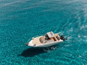 A stunning aerial view of a speedboat cruising through crystal-clear turquoise waters, perfect for exploring coastal destinations.