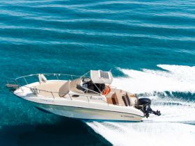 A sleek speedboat glides through crystal-clear waters, showcasing its elegant design and performance — perfect for thrilling adventures on the open sea.