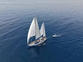 Aerial view of a beautiful sailboat navigating through calm blue waters, showcasing the elegance of sailing adventures.