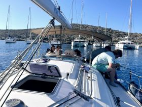 A group enjoys a day of fishing aboard a sailboat, surrounded by scenic waters and other vessels — perfect for a relaxing nautical adventure.