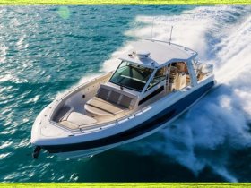 A stunning aerial view of a sleek speedboat cruising through vibrant turquoise waters, showcasing its elegant design and powerful performance.