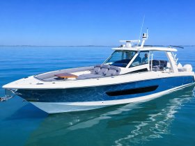 A sleek speedboat glides through calm waters, showcasing its modern design and spacious seating — perfect for thrilling adventures on the water.