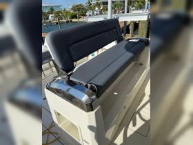 A close-up view of a comfortable seating area on a boat, showcasing the sleek design and functionality of the helm space.