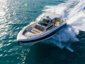 A stunning aerial view of a sleek speedboat cutting through the turquoise waters, showcasing its elegant design and performance on the open sea.