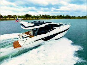 A stunning aerial view of a sleek yacht cruising through calm waters, showcasing its elegant design and performance.