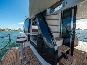 A beautifully designed interior of a yacht showcasing the helm and seating area, perfect for relaxing and enjoying the views while cruising.