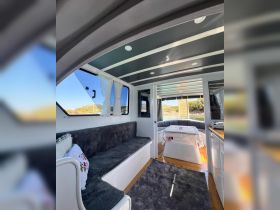 A cozy interior view of a boat cabin featuring comfortable seating and a dining area, perfect for relaxing during your nautical adventures.