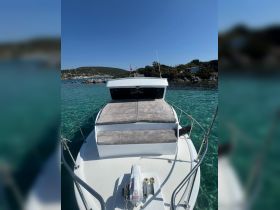 A clear view of the front deck of a boat, showcasing its sleek design and comfortable seating area, perfect for relaxing on the water.