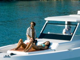 A group enjoys a relaxing day on a boat, sunbathing and soaking up the sun on the deck — perfect for summer outings and leisure on the water.