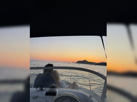 A couple enjoys a romantic sunset view from their boat, creating a perfect backdrop for memorable moments on the water.