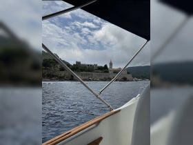 A scenic view from a boat showcasing a historic landmark along the coastline, perfect for exploring beautiful destinations by water.