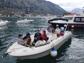 A lively group enjoys a boat ride in Kotor, surrounded by stunning scenery — perfect for exploring the beautiful coastline with friends.