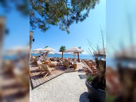 A vibrant beachside scene featuring lounge chairs and umbrellas, perfect for relaxation by the water. Ideal for sunbathing and enjoying coastal views.