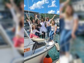 A lively group of friends celebrates on a boat, showcasing joy and camaraderie against a picturesque marina backdrop — perfect for memorable outings and celebrations.