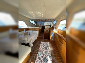Interior view of a spacious boat cabin featuring a cozy dining area and comfortable seating, perfect for relaxing and enjoying meals while on the water.