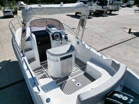 An interior view of a sleek boat helm showcasing the console and seating area, perfect for a day out on the water.