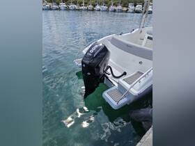 A close-up view of an outboard motor on a sleek boat docked in calm waters, showcasing the vessel's design and functionality.