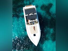 Aerial view of a woman sunbathing on the deck of a boat in crystal-clear waters — a perfect scene for relaxation and enjoying the sun.