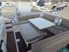 A cozy lounge area inside a boat featuring comfortable seating and decorative pillows, perfect for relaxing during a day on the water.