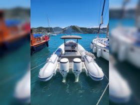 A sleek speedboat docked in clear turquoise waters, showcasing its modern design and powerful twin engines — perfect for thrilling adventures on the water.